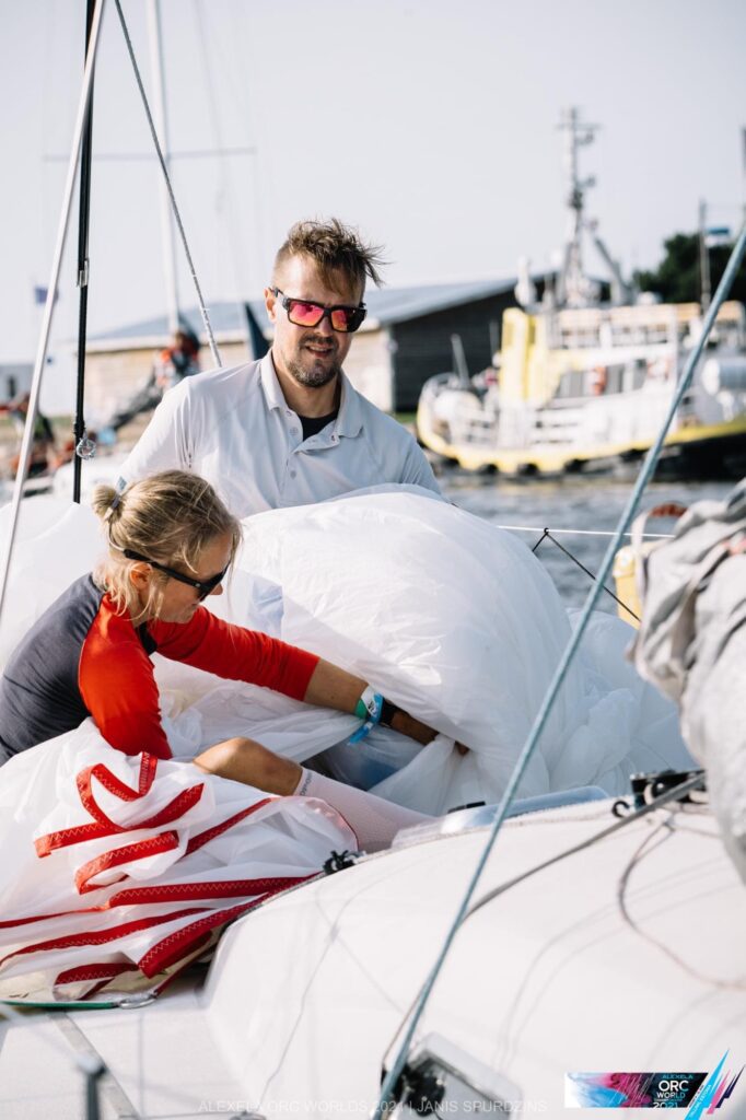 Noora stuffing the spinnaker below with the help of a crew member onboard. 